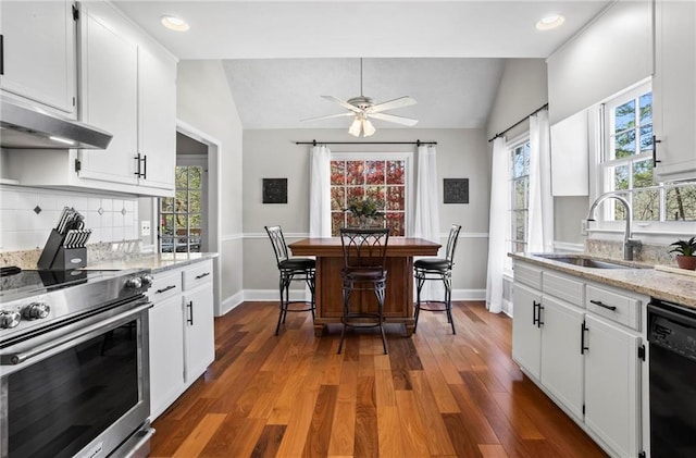 kitchen featuring a sink, stainless steel range with electric stovetop, black dishwasher, a wealth of natural light, and lofted ceiling
