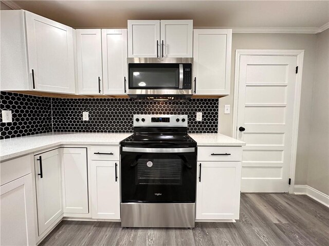 kitchen featuring ornamental molding, tasteful backsplash, wood-type flooring, white cabinetry, and stainless steel appliances