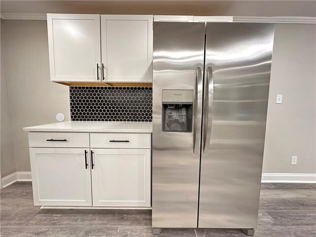 kitchen featuring white cabinetry, stainless steel fridge with ice dispenser, and crown molding