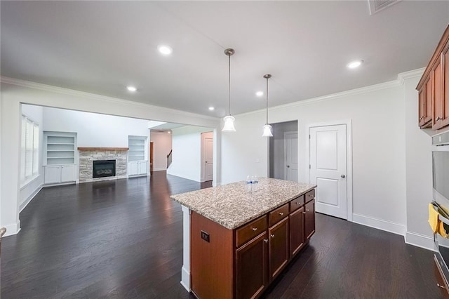 5789 Creek Indian Dr, Sugar Hill, GA 30518 - kitchen featuring crown molding, dark wood finished floors, baseboards, a kitchen island, and a fireplace