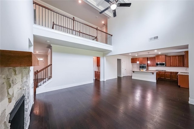 5789 Creek Indian Dr, Sugar Hill, GA 30518 - unfurnished living room with a towering ceiling, dark wood-style flooring, ceiling fan, baseboards, and stairway