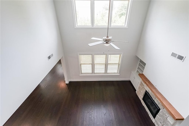 5789 Creek Indian Dr, Sugar Hill, GA 30518 - unfurnished living room featuring a fireplace, ceiling fan, a towering ceiling, dark wood-type flooring, and baseboards