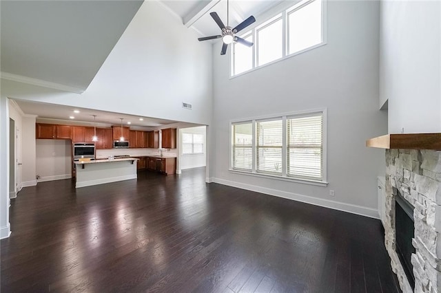 5789 Creek Indian Dr, Sugar Hill, GA 30518 - unfurnished living room with a fireplace, a ceiling fan, dark wood-type flooring, baseboards, and a high ceiling