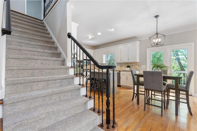 dining space featuring stairway, a chandelier, crown molding, light wood finished floors, and recessed lighting