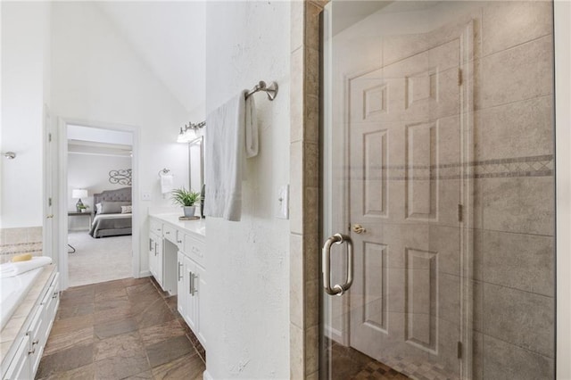 bathroom featuring vanity, a stall shower, lofted ceiling, and ensuite bathroom