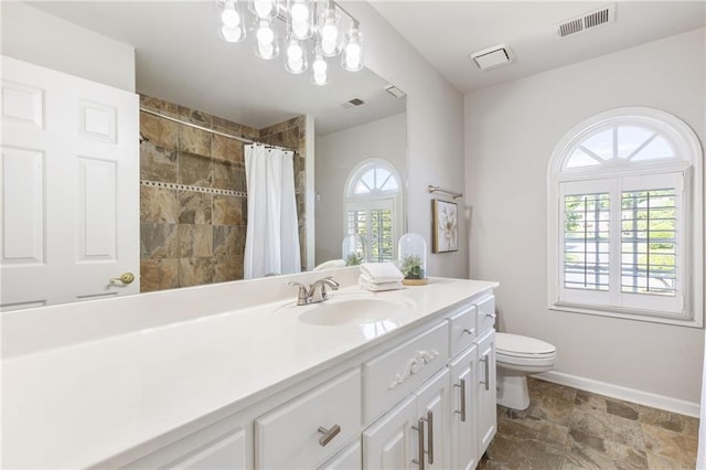 full bath with toilet, baseboards, tiled shower, vanity, and stone finish flooring