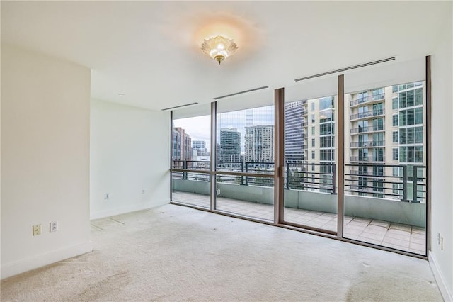 carpeted empty room featuring floor to ceiling windows and a healthy amount of sunlight