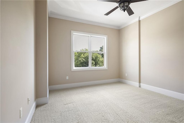 spare room with ornamental molding, light carpet, ceiling fan, and baseboards