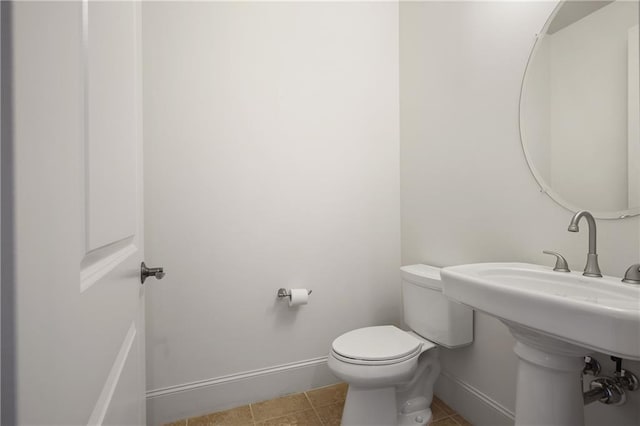 bathroom featuring baseboards, toilet, and tile patterned flooring