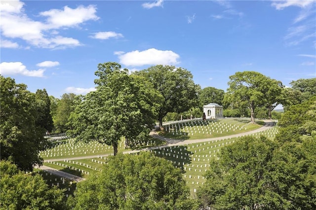 surrounding community featuring fence and view of wooded area