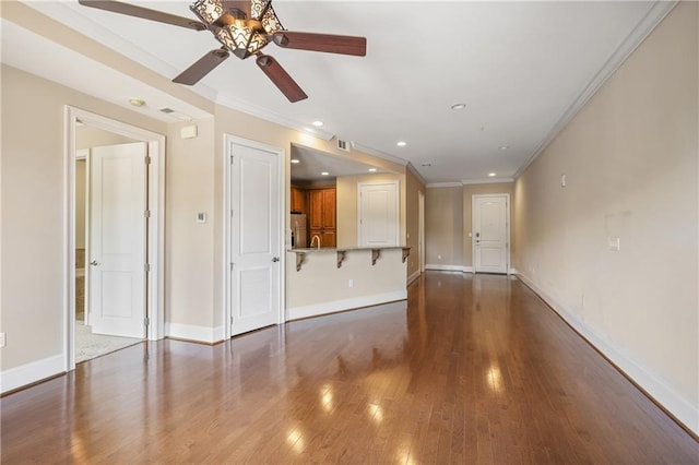 unfurnished living room featuring ceiling fan, ornamental molding, baseboards, wood finished floors, and recessed lighting