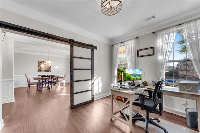 office area featuring crown molding, a barn door, and hardwood / wood-style flooring