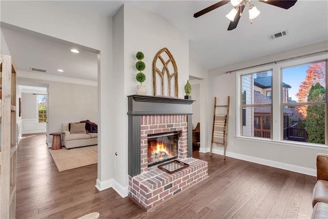 living room featuring ceiling fan, a brick fireplace, vaulted ceiling, and dark hardwood / wood-style floors