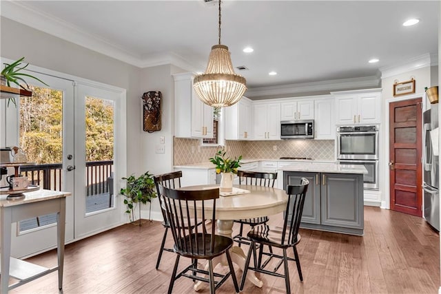 dining area featuring a notable chandelier, crown molding, and hardwood / wood-style floors