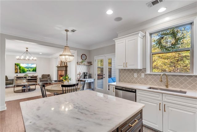 kitchen featuring sink, stainless steel dishwasher, tasteful backsplash, and white cabinetry