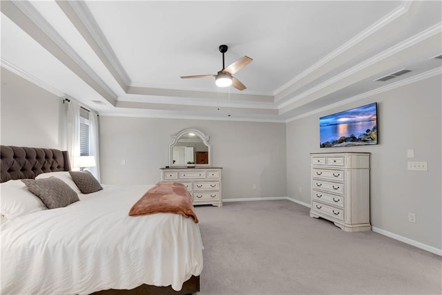 carpeted bedroom with ceiling fan, crown molding, and a tray ceiling