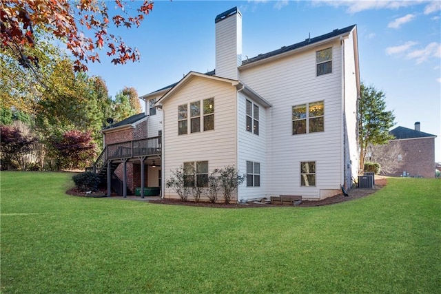 rear view of house with a deck, cooling unit, and a lawn