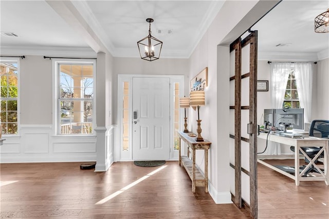 entryway featuring ornamental molding, dark hardwood / wood-style flooring, and an inviting chandelier