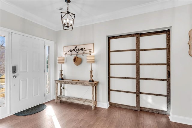 entryway featuring crown molding, a chandelier, and hardwood / wood-style floors