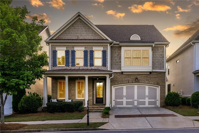 3380 Labrouste Cv, Duluth, GA 30097 - view of front of home featuring covered porch, concrete driveway, an attached garage, a shingled roof, and stone siding