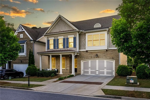 3380 Labrouste Cv, Duluth, GA 30097 - craftsman-style home with an attached garage, driveway, stone siding, and a porch