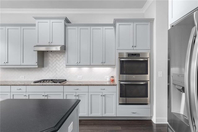 3380 Labrouste Cv, Duluth, GA 30097 - kitchen featuring crown molding, decorative backsplash, dark wood-style flooring, light stone counters, and stainless steel appliances