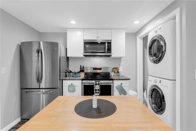 kitchen featuring white cabinetry, appliances with stainless steel finishes, and stacked washer / drying machine