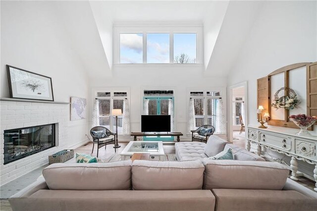 living room with high vaulted ceiling and a fireplace