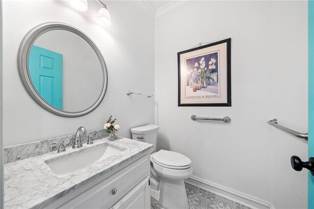 half bathroom featuring ornamental molding, toilet, and vanity