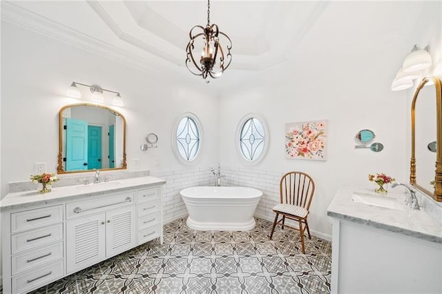 full bath with two vanities, a chandelier, a soaking tub, a wainscoted wall, and tile patterned floors