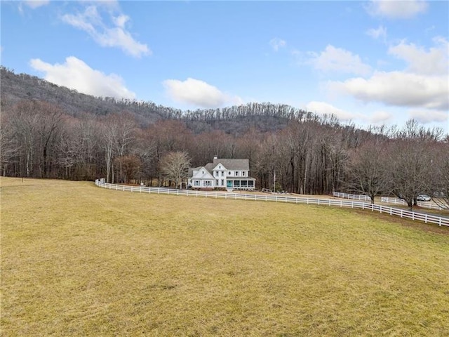view of yard featuring a view of rural / pastoral area and a wooded view