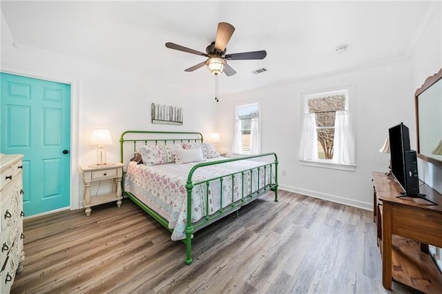 bedroom featuring light wood-style flooring, a ceiling fan, and baseboards