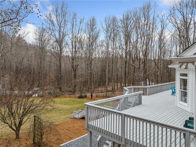 wooden terrace featuring a yard and a forest view