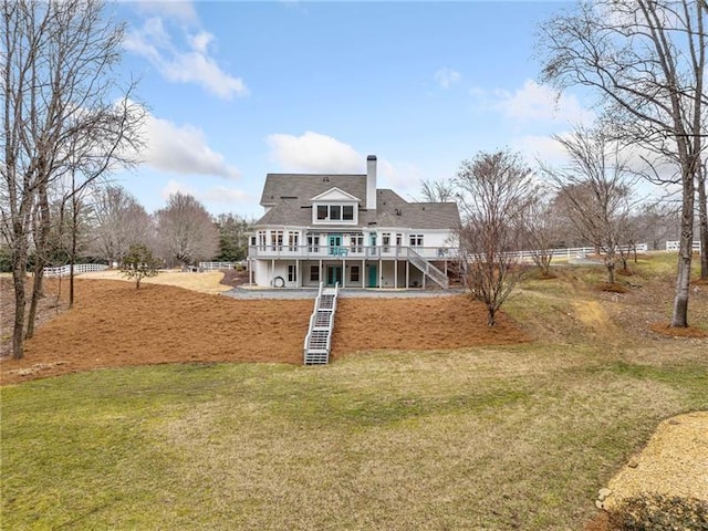 rear view of property with stairway, a deck, a chimney, and a yard