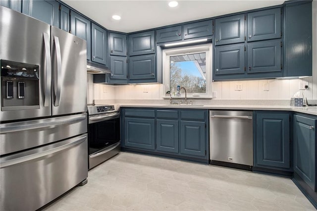 kitchen with stainless steel appliances, light countertops, and blue cabinets