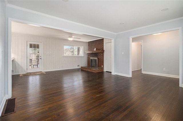 unfurnished living room featuring ornamental molding, dark wood-type flooring, a brick fireplace, and visible vents