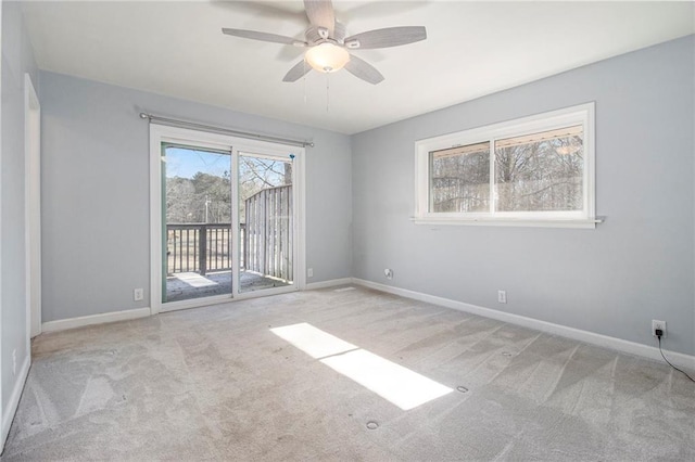 empty room featuring light carpet, baseboards, and a ceiling fan