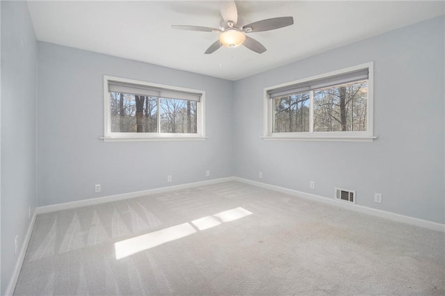 unfurnished room with light colored carpet, visible vents, and baseboards