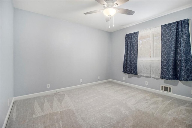 carpeted spare room with visible vents, ceiling fan, and baseboards