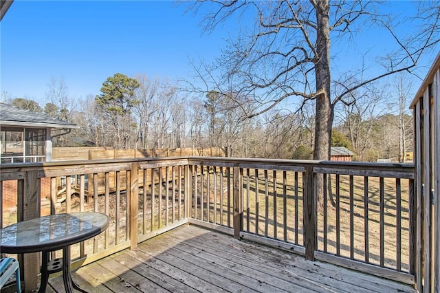 wooden terrace featuring a sunroom and fence