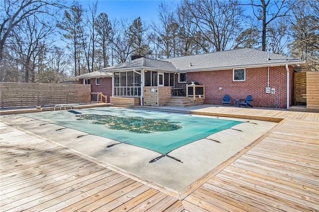 view of pool with fence, a sunroom, a diving board, a wooden deck, and a fenced in pool