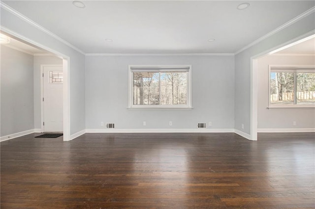 spare room featuring crown molding, visible vents, and dark wood finished floors