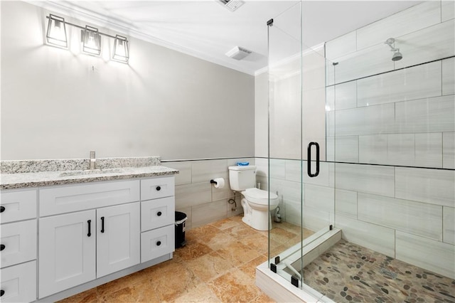 bathroom with toilet, a stall shower, crown molding, and tile walls