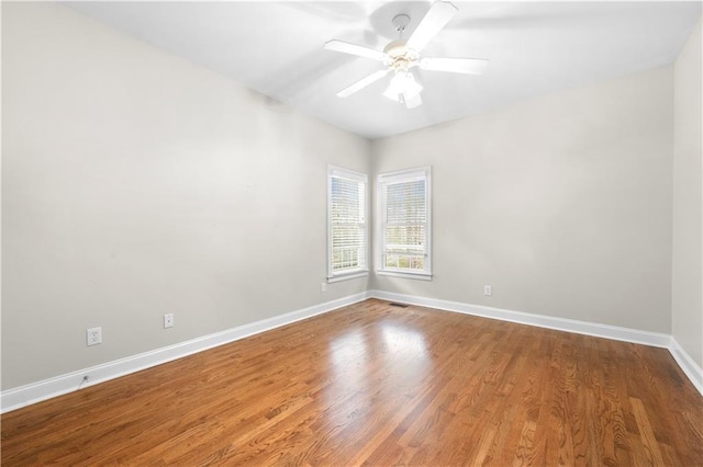 empty room featuring visible vents, baseboards, a ceiling fan, and wood finished floors