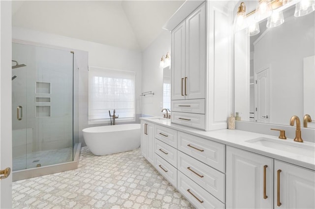 bathroom with lofted ceiling, double vanity, a stall shower, and a sink