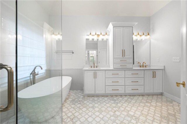 full bath featuring double vanity, a soaking tub, a sink, and tile patterned floors