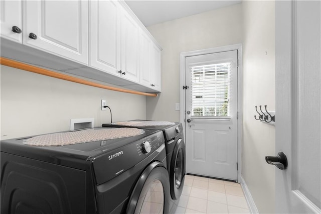 clothes washing area with separate washer and dryer, light tile patterned flooring, cabinet space, and baseboards