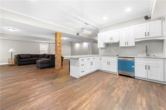 kitchen with crown molding, a peninsula, wood finished floors, dishwasher, and under cabinet range hood