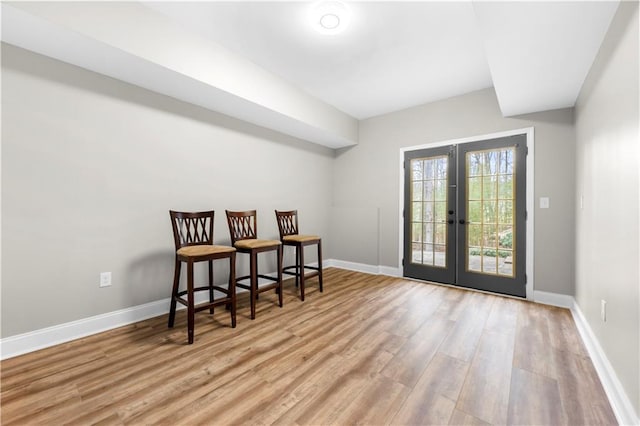 foyer entrance with french doors, baseboards, and wood finished floors