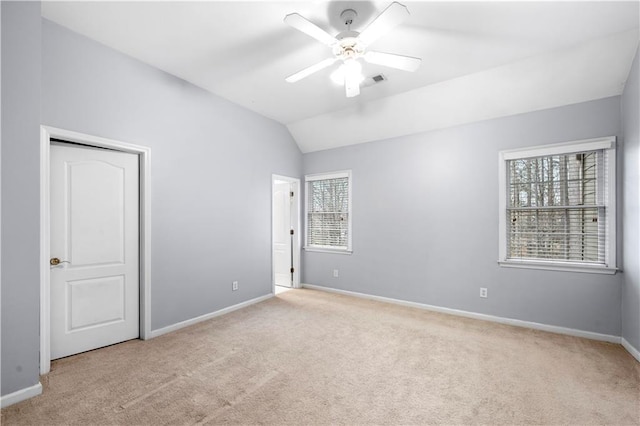 spare room with baseboards, visible vents, a ceiling fan, lofted ceiling, and carpet floors